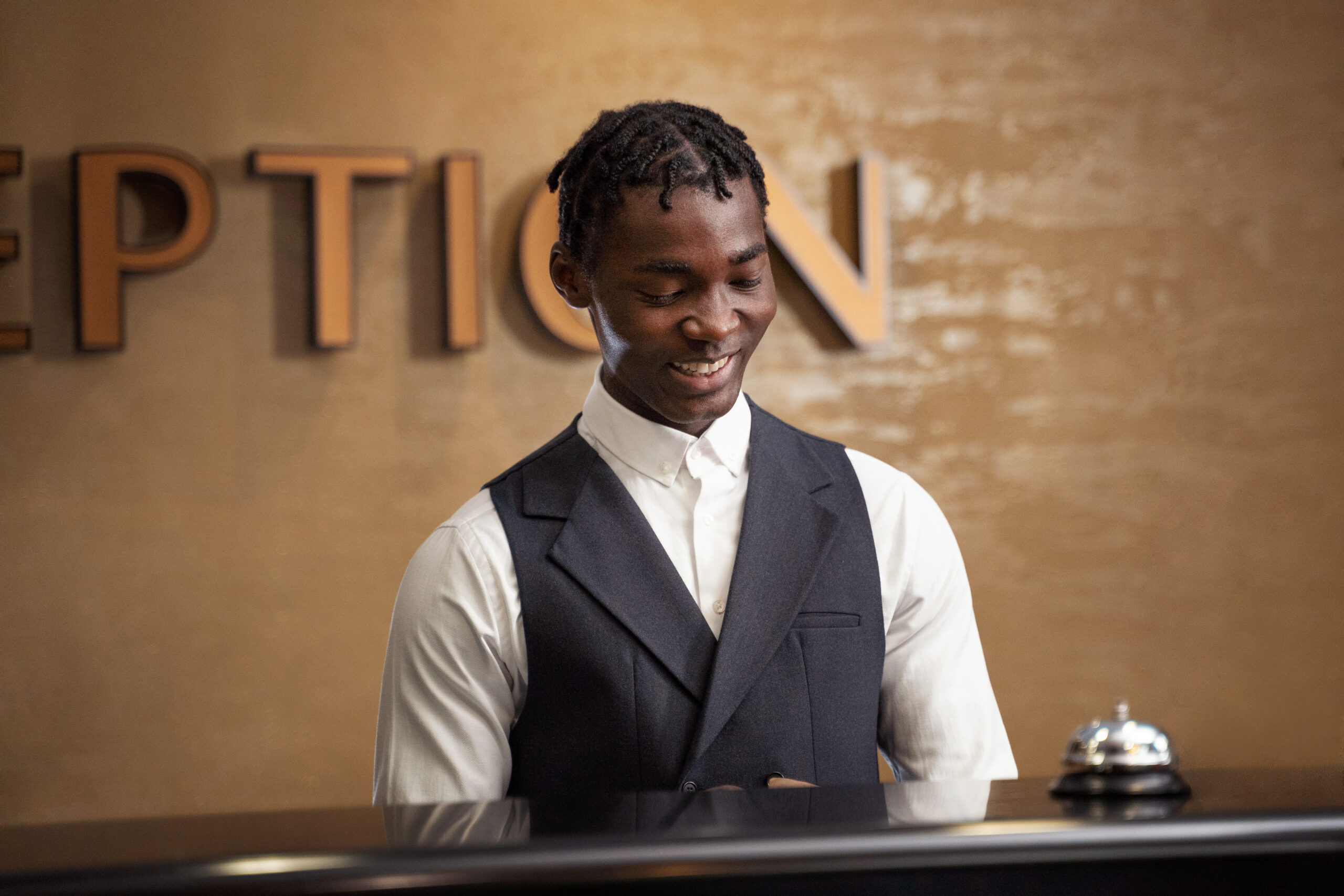 homme-souriant-vue-de-face-travaillant-a-la-reception