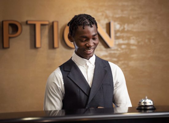 homme-souriant-vue-de-face-travaillant-a-la-reception